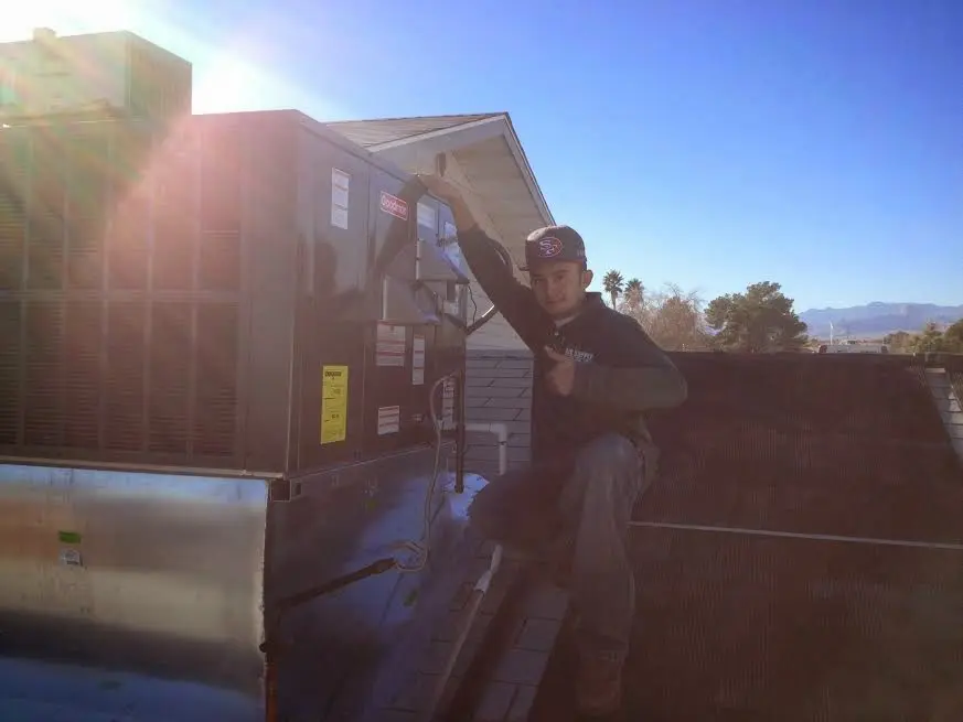 HVAC technician performing Heat Pump Repair on a rooftop unit in Ocean Shores